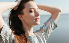 Girl inhales the fresh sea air after her sinus lift surgery in San Francisco.